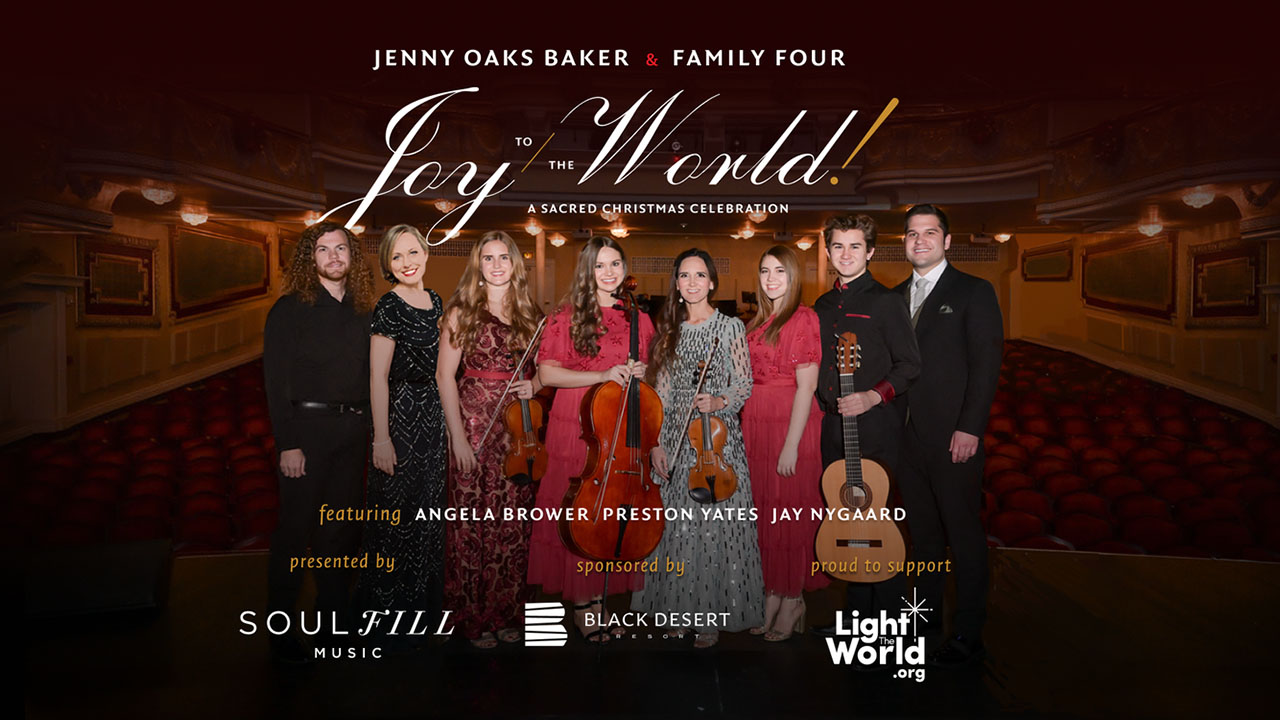 A group of performers standing on stage with words, Joy to the World.